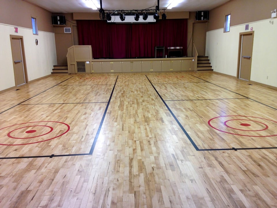 Hardwood gymnasium floor with painted court markings